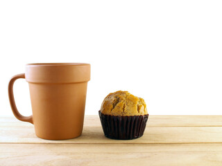 side of simple vintage baked clay coffee cup and banana cupcake on desk isolated on transparent