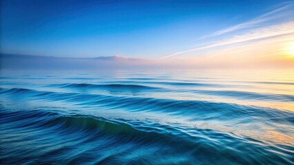 Obraz premium Gentle waves caress a serene ocean surface as morning fog softly settles, creating a mystical atmosphere with delicate ripples and soft blue hues , gentle, sea