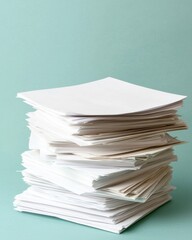 A stack of unmarked white papers on a soft green background, suggesting an organized yet simple workspace aesthetic.