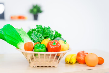 A nutritionist's table neatly arranged with a basket overflowing with fresh vegetables and fruits, including lettuce, kale, bell peppers, bananas, onions, and tomatoes, health and nutrition.