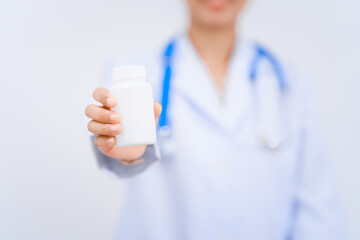 A young Asian nutritionist and doctor, smiling happily while wearing a stethoscope and white lab...