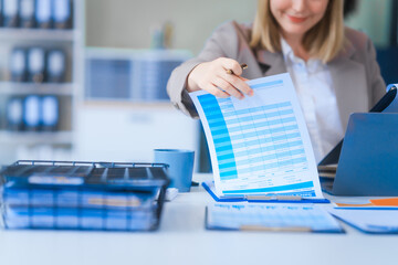 A young Russian woman in formal suit works diligently in business office, analyzing financial...