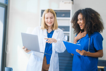 Young African American and Russian woman, both scientists, collaborate to analyze blood samples,...