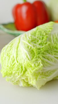 Close up of a whole chinese lettuce in the kitchen, healthy vegetable for salad, vegetarian, vitamin, vertical shot, more vegetables in the background