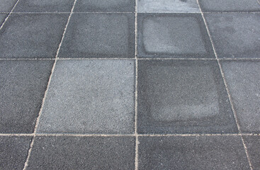 Texture of square paving tile. Pattern of gray sidewalk tiles in the street. Concrete pavers close up background.