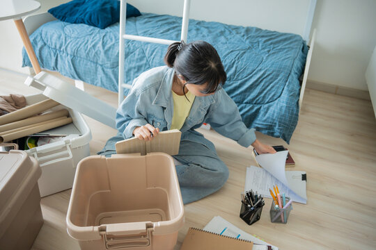 Student asian woman organize room unpack in dorm room college student moving to new  university dormitory or preparing to move out.