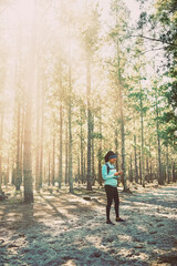 Phone, hiking and research with woman in forest for adventure, location app and explore guide. Exercise, trekking and trail map with person in park conservation for holiday, travel and environment