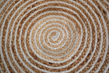 Intricate spiral design of woven natural fibers on a rustic surface