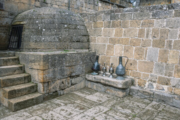 Antique metal vessels for water and wine. Copper jugs in an ancient city near a stone wall. Antique...
