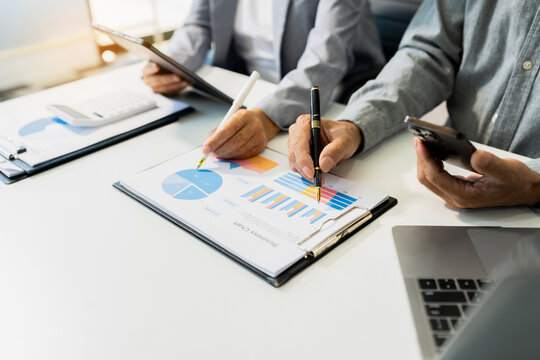 Teamwork process, Business team using a calculator to calculate the numbers of statistic business profits growth rate on documents graph data.
