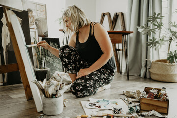 Art, creativity and paint, woman in home studio with brush, canvas and inspiration with colors in...