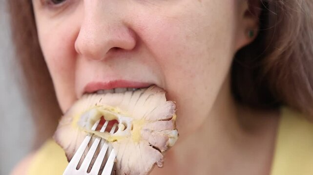 In a restaurant, a woman eats delicious and healthy food. Close-up. Fillet of sturgeon fish