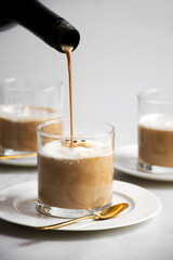 Alcoholic drink being poured on affogato glass