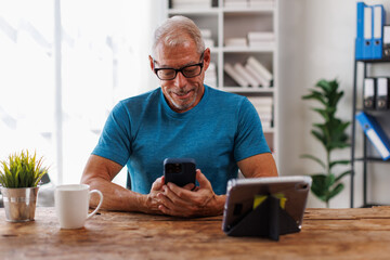 Senior, man having remote online work hybrid meeting or distance job interview, holding cup of coffee, gesturing with hands during virtual video conference call from home.