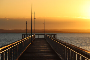 Wellington Point pier extending into a calm ocean at sunset