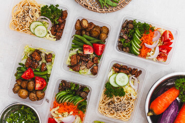 a table topped with plastic containers filled with food ingredients for healthy and balanced nutrition meal preparation for food delivery