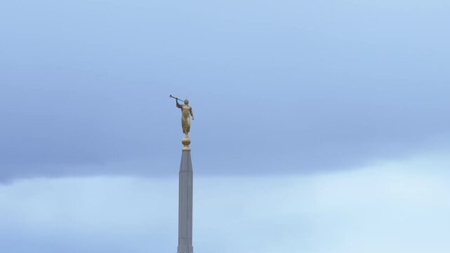 Aerial LDS Temple spire Angel Moroni cloud sky Utah circle. The Church of Jesus Christ of Latter-day Saints, LDS Mormon religion. Sacred building for eternal worship. Residential neighborhood.