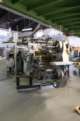 A complex machine stands in a factory hall