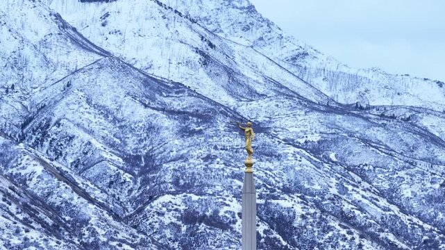 Aerial LDS Temple spire Angel Moroni mountain Payson Utah circle. The Church of Jesus Christ of Latter-day Saints, LDS Mormon religion. Sacred building for eternal worship. Residential neighborhood.