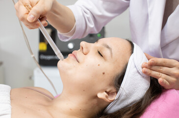 Face Beauty Treatment. Close up of female client getting facial gas-liquid oxygen water epidermal...