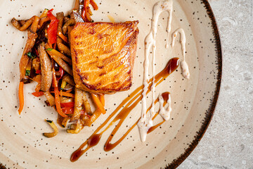 A beautifully arranged plate showcases a perfectly grilled fish fillet alongside vibrant sautéed...