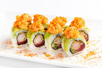 Colorful sushi rolls are artfully arranged on a plate, showcasing vibrant avocado and spicy seafood topping. A culinary delight perfect for any occasion, bringing fresh flavors to the table.