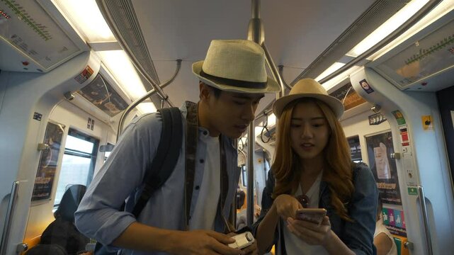 Young couple Asian tourist enjoy travel in Bangkok with sky train in Thailang.