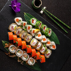 An exquisite arrangement of sushi rolls showcases a variety of colors and textures, with fresh fish, avocado, and delicate garnishes. The platter is beautifully presented with a touch of elegance. 