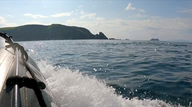 POV fast boat in seas off Scotland islands with ship in background