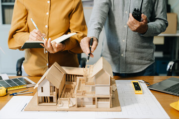 Engineer desk with object paper and tablet with blurry engineer teamwork hardworking