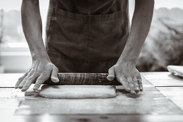 Artisan Baker Rolls Dough for Bread Preparation