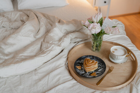 Breakfast in bed &ndash; heart shaped pancakes coffee, flowers and love card