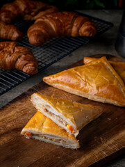 Fresh Baked puff pastry pie with filling on wooden cafe table