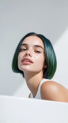 Obraz premium Young woman with trendy green hair posing against a minimalist backdrop in bright natural light during daytime