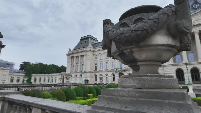 The elegant Royal Palace of Brussels with meticulously maintained gardens and cloudy skies.