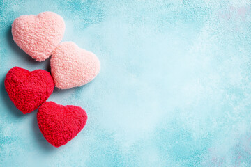 Obraz premium Red and Pink Fleece Hearts on Blue Textured Background Romantic Decoration for Valentine's Day with Copy Space