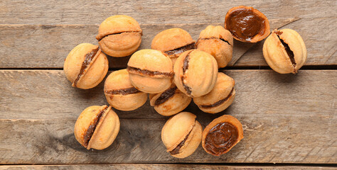 Sweet walnut shaped cookies with boiled condensed milk on wooden background