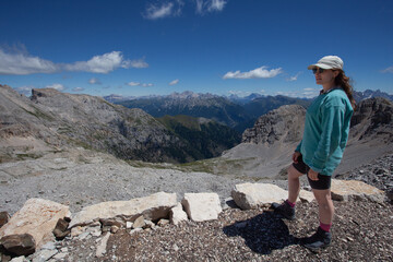 Girl in front of beautiful summer Dolomites panorama, Mount Latemar, Trentino, Italy. Travel in Dolomites. Tourism. Traveling photography and outdoor sport activity concept