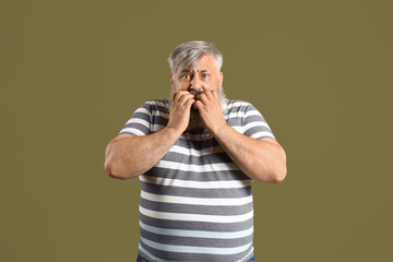 Afraid mature man on green background