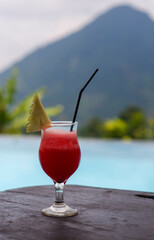 Drinks and snacks are served at tables with a swimming pool in the background