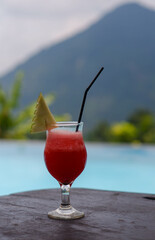 Drinks and snacks are served at tables with a swimming pool in the background
