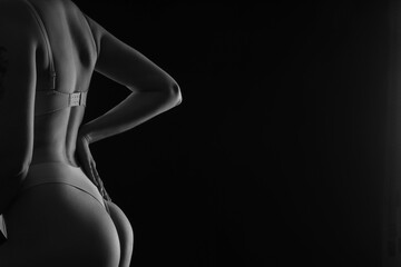 Naklejka premium Silhouette of attractive young woman in underwear on dark background, closeup