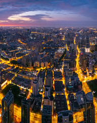 Aerial view of Shanghai skyline and bright city streets at dawn