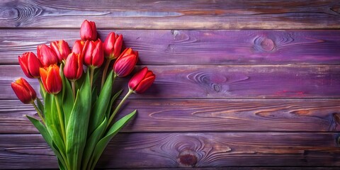 A vibrant bouquet of red tulips rests on a rustic wooden surface, their green stems creating a natural contrast against the purple backdrop.