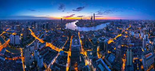 Aerial view of Shanghai skyline and bright city streets at dawn