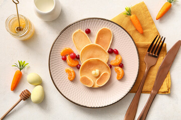 Funny Easter bunny pancakes with painted eggs on white background