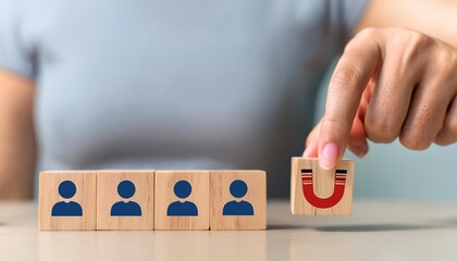 Attracting online customer and lead generation concept. Digital inbound marketing, customer retention strategy.Hand hold wooden cube with the icon big magnet  attract many people  grey background new