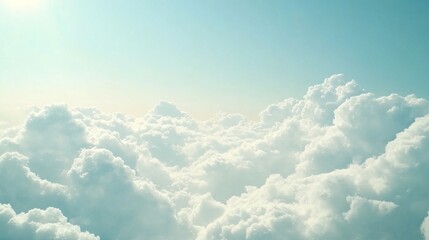 Fluffy white clouds across a gradient sky with soft sunlight