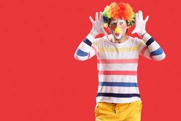 Portrait of funny clown on red background. April Fool's day celebration