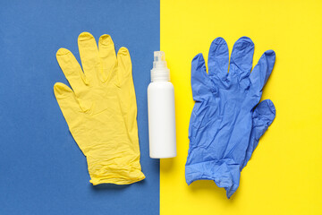 Bottle of sanitizer and rubber gloves on color background